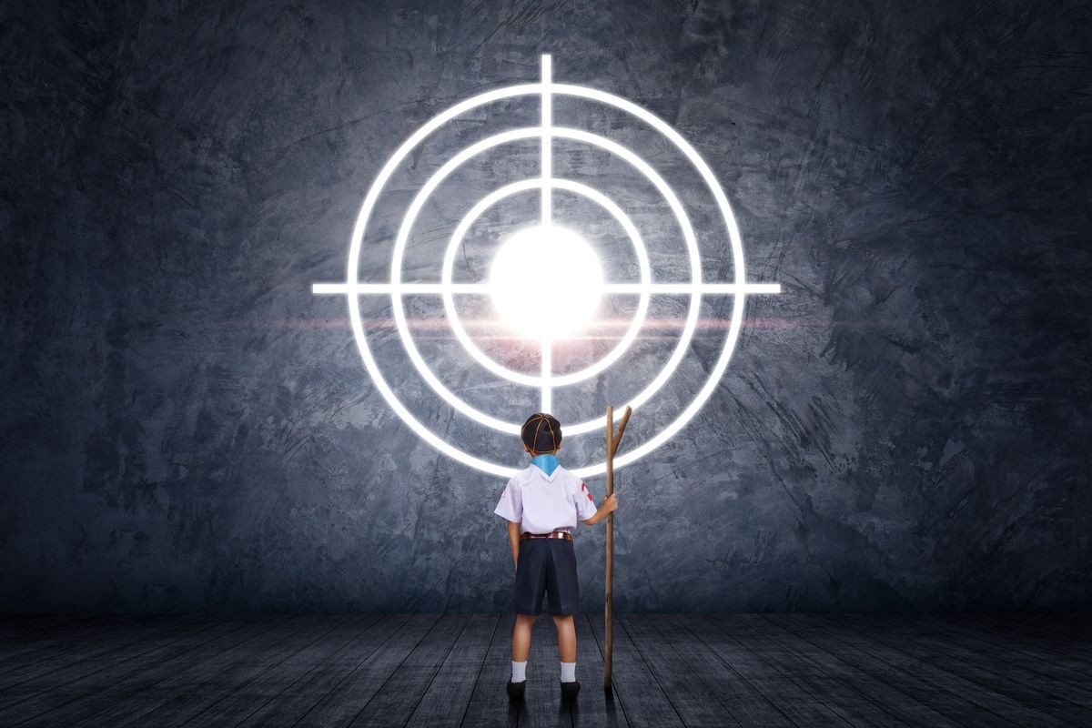 Little boy standing looking at target in front concrete wall. Kid in the Scout series begins the adventure. Concept of achieving a goal. Success, leader and winner concept